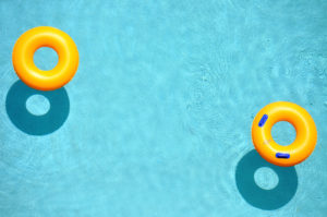 Yellow pool float, pool ring in cool blue refreshing blue pool, room for your text